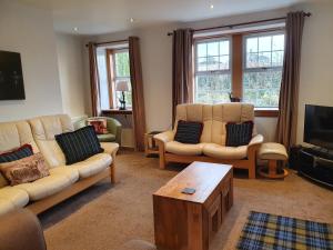 a living room with two couches and a coffee table at Wee Gem Cottage in Edinburgh