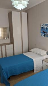 een slaapkamer met een bed met een blauwe deken bij appartamento mariani in Riccione