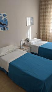 twee bedden naast elkaar in een kamer bij appartamento mariani in Riccione