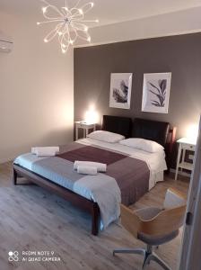 a bedroom with a large bed and a chandelier at Bouganville Residence in Calatabiano +79 photos