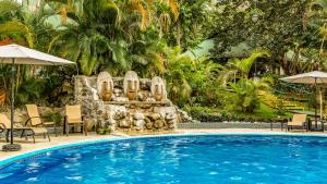 a pool at a resort with a stone fountain at Hotel Villas Rio Mar in Dominical +46 photos