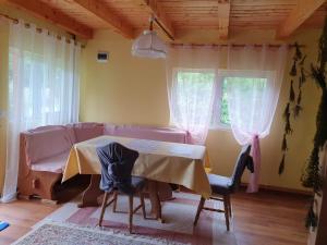 a living room with a table and a couch at Casa Dor de Ea in Dâmbovicioara