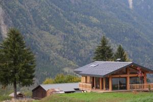 une maison sur une colline avec des montagnes en arrière-plan dans l'établissement Modern Chalet With Garden Chamonix, à Chamonix-Mont-Blanc