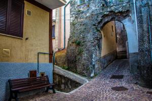 eine Bank neben einem Gebäude mit einer Steinmauer in der Unterkunft Da Nonna Pasqualina in Ciorlano