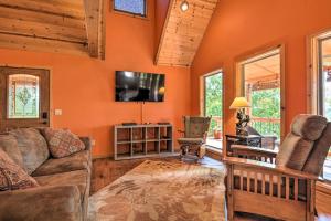 een woonkamer met een bank en een tv bij Spacious Log Cabin with Fire Pit and Game Room! in Eureka Springs