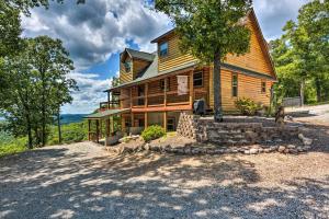 una grande casa in legno con un albero di fronte di Spacious Log Cabin with Fire Pit and Game Room! a Eureka Springs