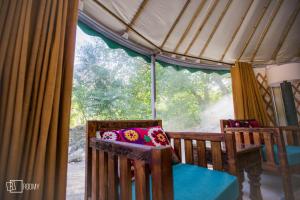 Hini的住宿－Roomy Yurts, Minapin Nagar Hunza，带2把椅子和窗户的房间