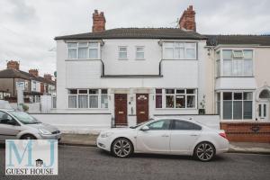 a white car parked in front of a guest house at M and J Guest House in Cleethorpes