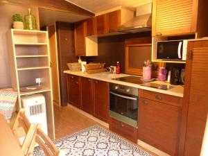 a kitchen with wooden cabinets and a stove top oven at La Maison Blanche in Courlans