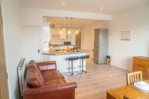 a living room with a couch and a kitchen at The Haven Keswick - Spacious Central Apartment in Keswick +24 photos