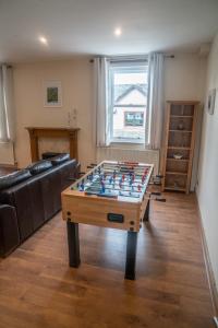 a living room with a foosball table in the middle at The Haven Keswick - Spacious Central Apartment in Keswick