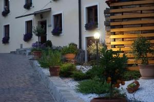 a courtyard of a house with potted plants and a building at Sobe Proštija in Ptuj