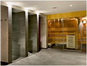 uma casa de banho com uma cabina de duche ao nível do chão e uma porta de vidro em "Quality Hosts Arlberg" Hotel Garni Mössmer em Sankt Anton am Arlberg