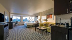 a hotel room with a bed and a living room at Holiday Inn Express & Suites Colorado Springs Central by IHG in Colorado Springs