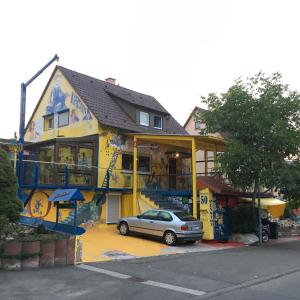 a house with a car parked in front of it at Pension Weinsberg in Weinsberg