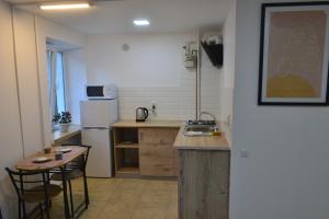 eine kleine Küche mit einem Waschbecken und einem Tisch in der Unterkunft Smart in Ternopil