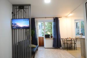 ein Wohnzimmer mit einem TV und einem Tisch mit Stühlen in der Unterkunft Smart in Ternopil