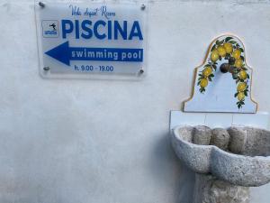 a sign on a wall with a bowl of grapes at Veda elegant rooms in Fiumefreddo di Sicilia