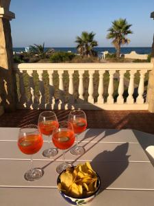 Drei Weingläser und eine Schale Chips auf dem Tisch. in der Unterkunft Beach House Villa Roca in Cullera