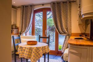 a kitchen with a table and a window with a tablecloth on it at Reayrt Ny Marrey in Kirkmichael