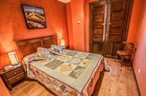 1 dormitorio con 1 cama en una habitación naranja en Hotel Rural Pajarapinta, en Molinaseca
