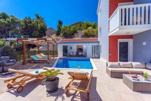 ein Hinterhof mit einem Swimmingpool und einem Haus in der Unterkunft Villa Matan - only 200m from the sandy beaches, private 28m2 pool in Omiš + 43 Fotos