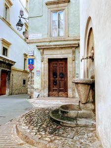 a building with a large wooden door on a street at Montella 2 in Spoleto