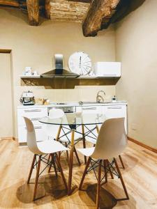 een keuken met een tafel en stoelen en een klok aan de muur bij Montella 2 in Spoleto