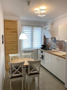 a kitchen with a table and chairs in a kitchen at Mia Apartament in Tulcea