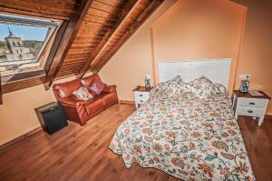 Un dormitorio con una cama y una silla y una ventana. en Hotel Rural Pajarapinta, en Molinaseca