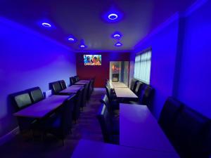 a dining room with purple lights and tables and chairs at Glorious catering & Restaurant BnB in Ocker Hill