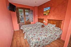Un dormitorio con una cama y un televisor. en Hotel Rural Pajarapinta, en Molinaseca 37 fotos más