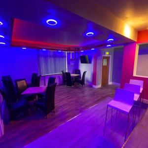 Pokój z fioletowymi lampkami, stołami i krzesłami w obiekcie Glorious catering & Restaurant BnB w mieście Ocker Hill