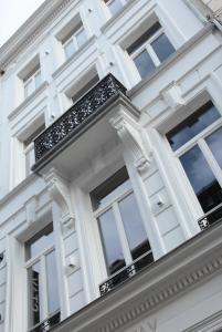 - un bâtiment blanc avec des fenêtres et un balcon dans l'établissement Maison Nationale City Flats & Suites, à Anvers