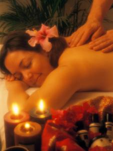 Eine Frau bekommt eine Massage in einer Badewanne mit Kerzen in der Unterkunft Anse Chastanet Resort in Soufrière
