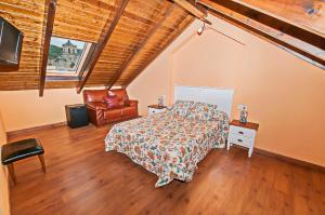 un dormitorio con una cama y una silla en Hotel Rural Pajarapinta, en Molinaseca