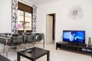 un soggiorno con TV, tavolo e sedie di Molino Fresh a Barcellona