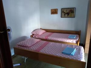 two beds in a room with pink and blue sheets at La Sirena Appartamento in Oliveri