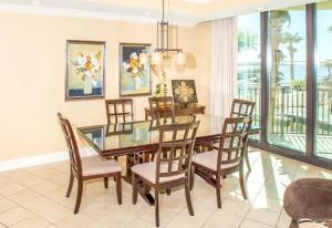 a dining room with a glass table and chairs at Phoenix on the Bay II in Orange Beach