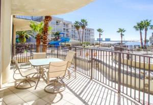 a balcony with a table and chairs and a view of the beach at Phoenix on the Bay II in Orange Beach