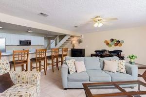 sala de estar con sofá azul y cocina en Bayview, en Orange Beach