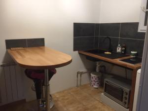 eine kleine Küche mit Tisch und Spüle in der Unterkunft Logement indépendant Au Bonheur cuisine piscine clim proche centre village #dentelles Montmirrail in Beaumes-de-Venise + 18 Fotos