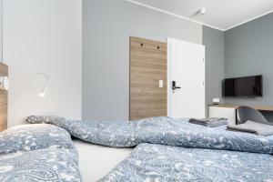 2 camas en una habitación con TV y sofá en Hugo, en Gdynia
