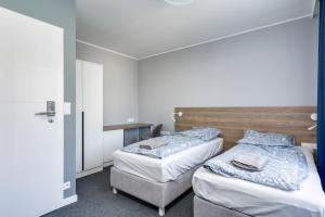 pokój z 2 łóżkami i krzesłem w obiekcie Hugo w mieście Gdynia