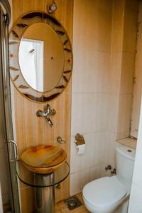 een badkamer met een toilet en een spiegel aan de muur bij My Hotel in Caïro