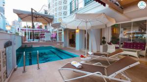 a swimming pool with two chairs and an umbrella at Wise Hotel & Spa - Adults Only in Antalya
