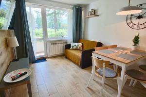 - un salon avec une table et un canapé dans l'établissement Apartment BazaTatry Parkowy, à Zakopane