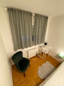 a room with a chair and a table and a window at Bizi Green - Zagreb South in Zagreb