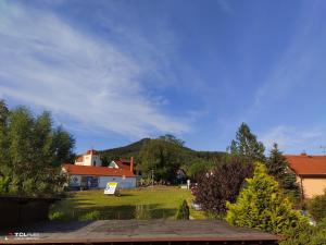 vista su un cortile con una casa e una montagna di Ferienwohnung und Pension Pia a Cvikov