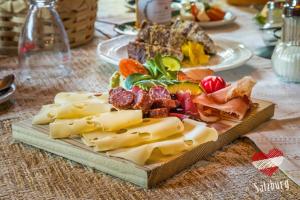 um prato de queijo e carnes numa mesa em ZITTRAUERHOF - Urlaub am Bauernhof Gastein em Bad Hofgastein